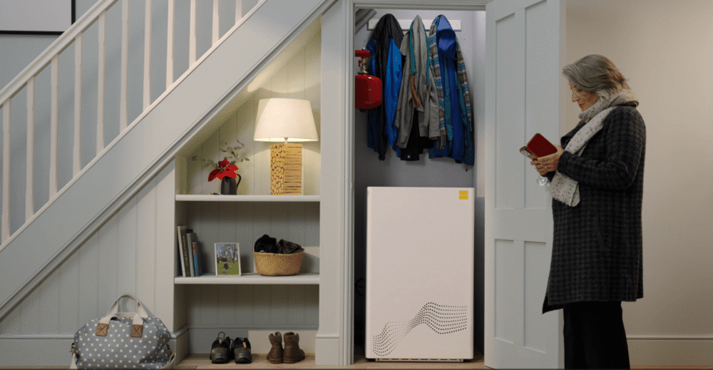 woman turns off her tepeo zeb heat battery boiler as she leaves the house