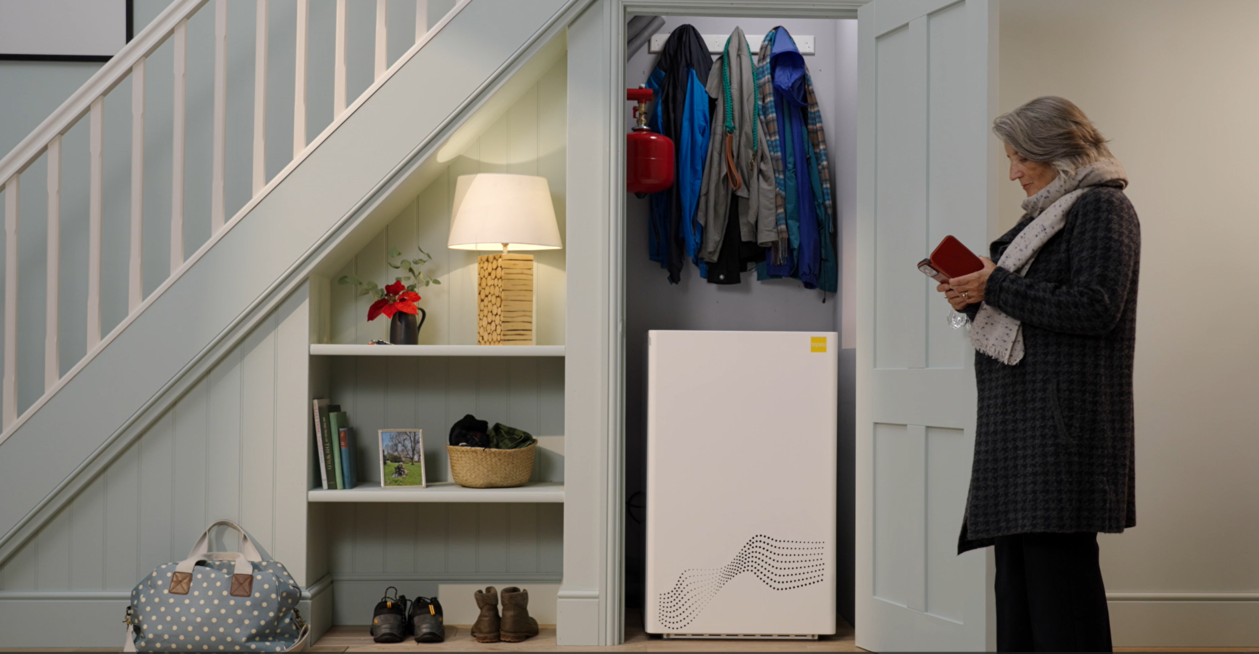 woman turns off her tepeo zeb heat battery boiler as she leaves the house